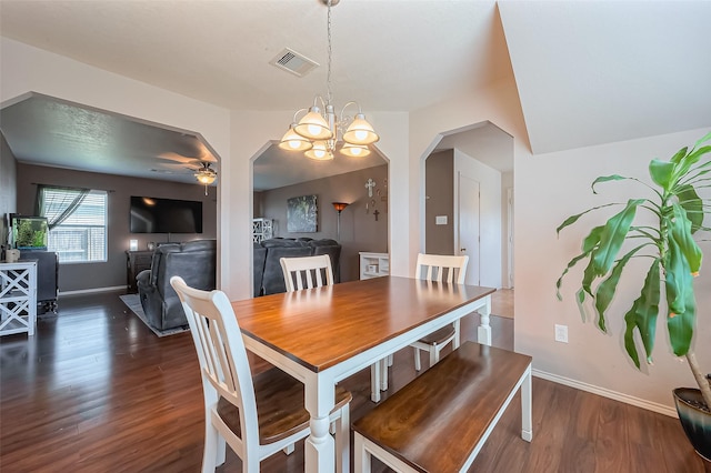 dining room featuring baseboards, visible vents, arched walkways, dark wood-type flooring, and ceiling fan with notable chandelier