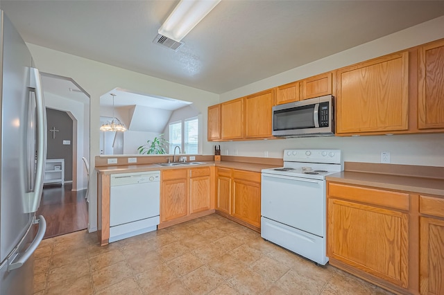 kitchen with visible vents, a peninsula, an inviting chandelier, a sink, and stainless steel appliances