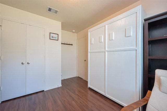 unfurnished bedroom featuring a closet, visible vents, and wood finished floors