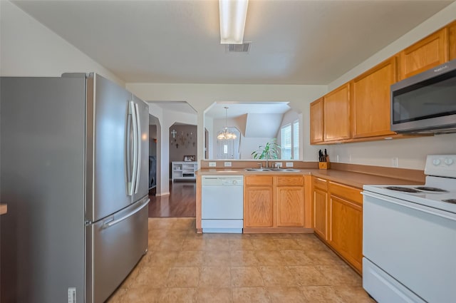 kitchen featuring visible vents, a notable chandelier, a sink, appliances with stainless steel finishes, and a peninsula