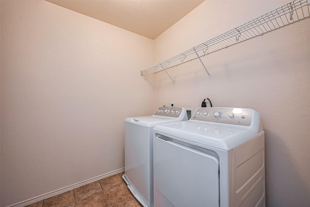 washroom with laundry area, washing machine and dryer, and baseboards