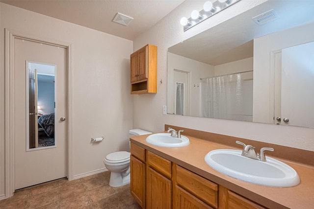 full bathroom with visible vents, toilet, and a sink