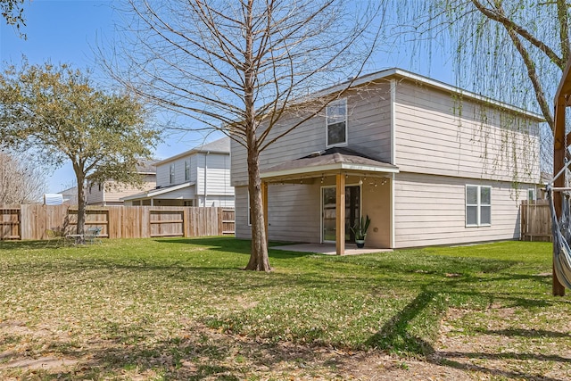 rear view of property with a fenced backyard, a lawn, and a patio