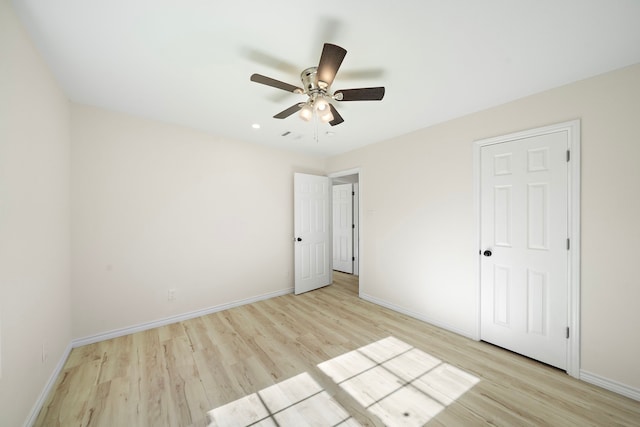 unfurnished bedroom featuring a ceiling fan, light wood-style floors, and baseboards