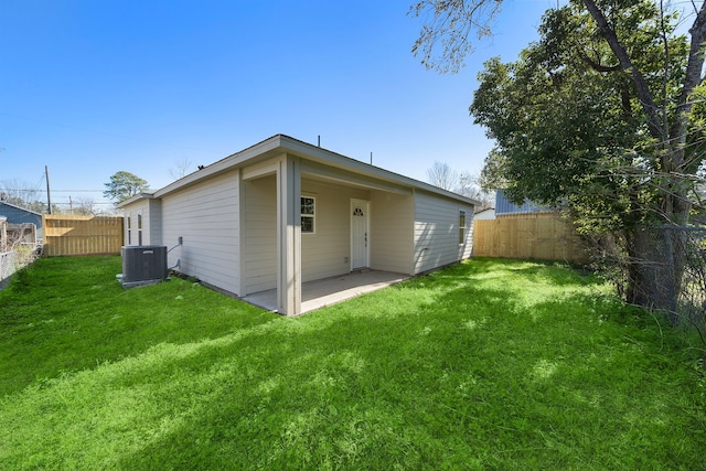 back of property with a lawn, central AC unit, a fenced backyard, and a patio area