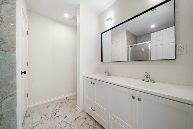 bathroom with baseboards, double vanity, a stall shower, marble finish floor, and a sink