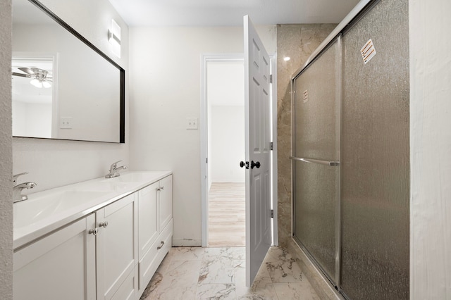 full bathroom featuring marble finish floor, a shower stall, a ceiling fan, and a sink