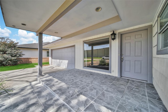 view of patio with concrete driveway and a garage