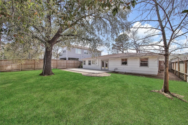 rear view of property with a yard, a patio area, and a fenced backyard