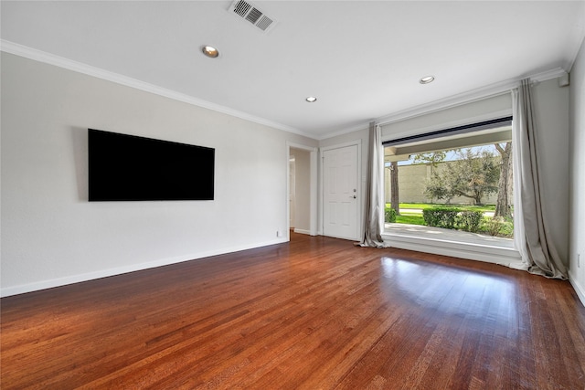 unfurnished living room featuring visible vents, crown molding, baseboards, and wood finished floors