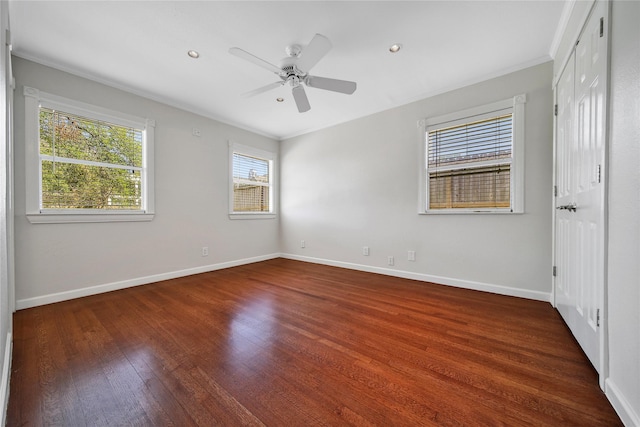 spare room featuring baseboards, wood finished floors, a ceiling fan, and ornamental molding