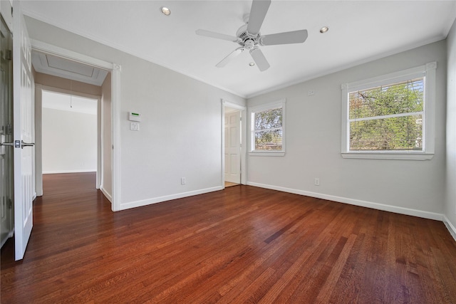 unfurnished room featuring a healthy amount of sunlight, attic access, baseboards, and wood finished floors