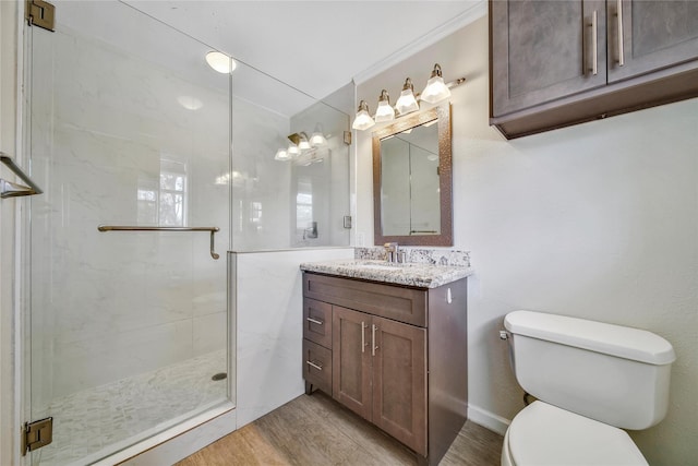 full bathroom with toilet, a stall shower, ornamental molding, wood finished floors, and vanity