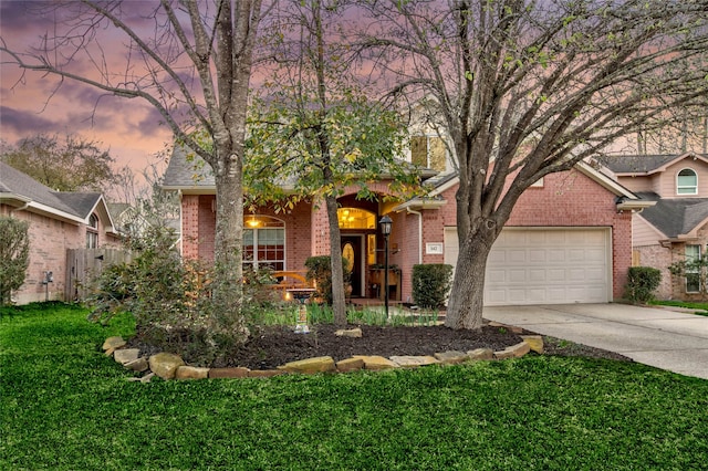 view of front facade with brick siding, an attached garage, concrete driveway, and a front yard