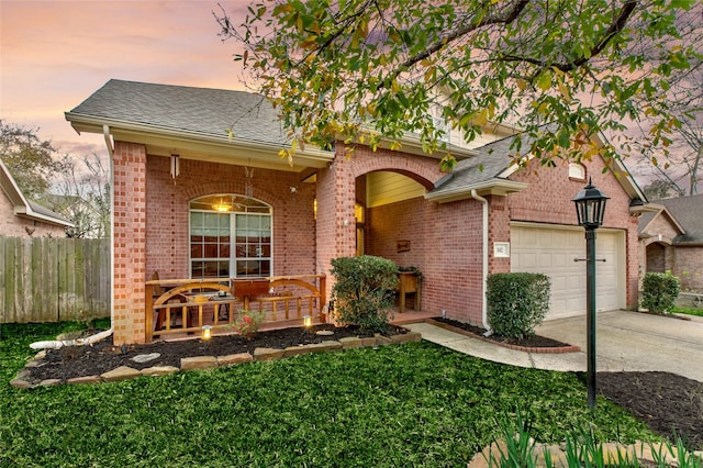 view of front of property with brick siding, fence, concrete driveway, covered porch, and a garage