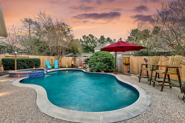 view of pool with a pool with connected hot tub, a fenced backyard, and a patio area