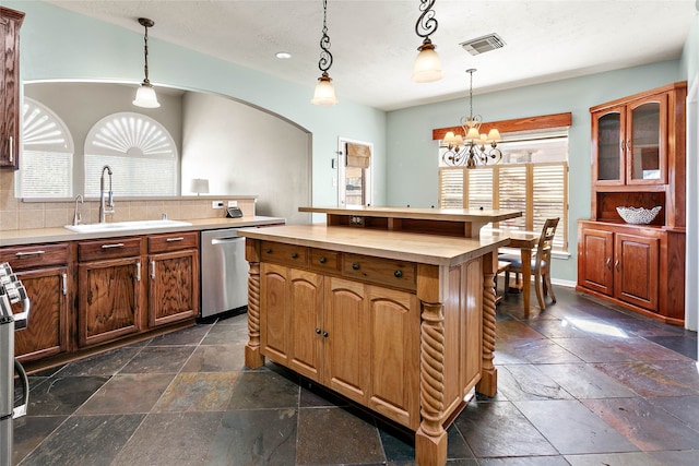 kitchen featuring visible vents, stainless steel dishwasher, stone tile flooring, a notable chandelier, and a sink