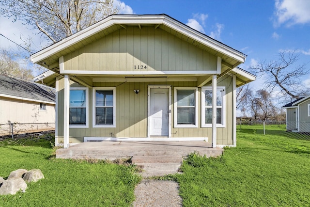 view of front of property featuring a patio, a front lawn, and fence