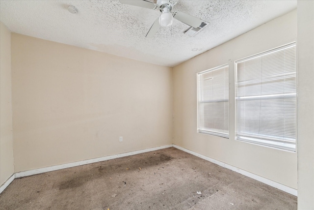 empty room featuring visible vents, baseboards, a textured ceiling, and ceiling fan