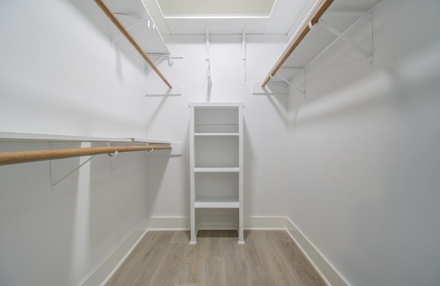 walk in closet with wood finished floors