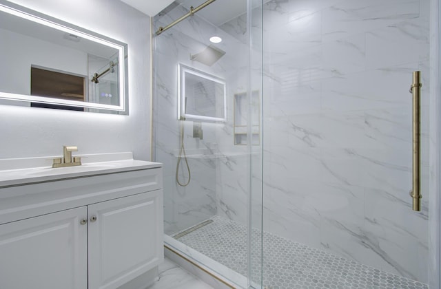 bathroom with vanity, marble finish floor, and a marble finish shower