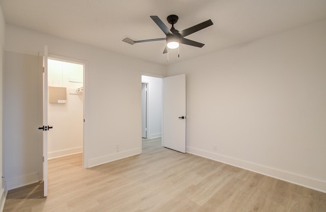 unfurnished bedroom featuring light wood-type flooring, a ceiling fan, a closet, baseboards, and a spacious closet