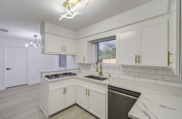 kitchen with visible vents, a notable chandelier, a sink, stainless steel dishwasher, and white cabinetry