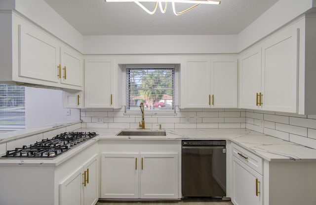 kitchen with stainless steel gas cooktop, dishwasher, light stone counters, white cabinetry, and a sink