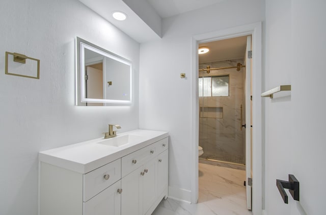 bathroom featuring vanity, toilet, marble finish floor, and a stall shower