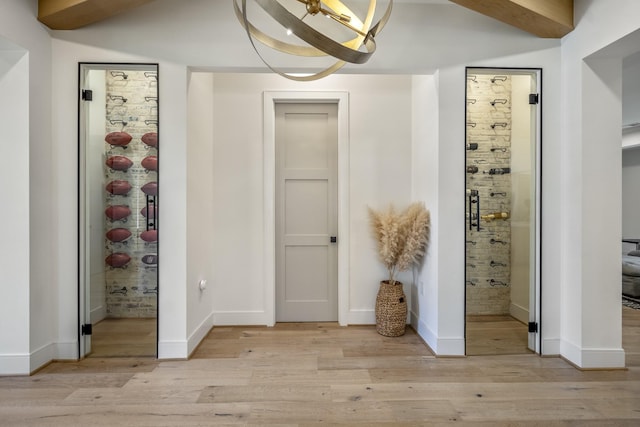 interior space with light wood-style floors, baseboards, and a chandelier