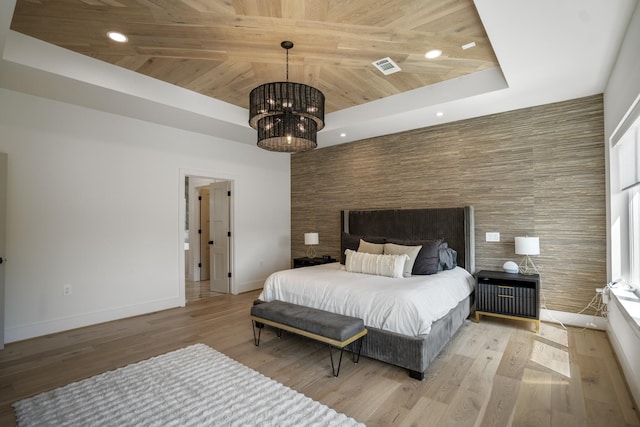 bedroom featuring a notable chandelier, light wood-style flooring, a tray ceiling, baseboards, and wood ceiling