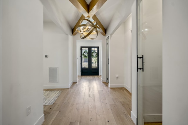 foyer entrance featuring a notable chandelier, visible vents, light wood-style flooring, and baseboards