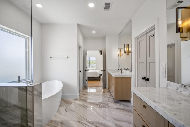 ensuite bathroom featuring a freestanding tub, visible vents, marble finish floor, ensuite bathroom, and vanity