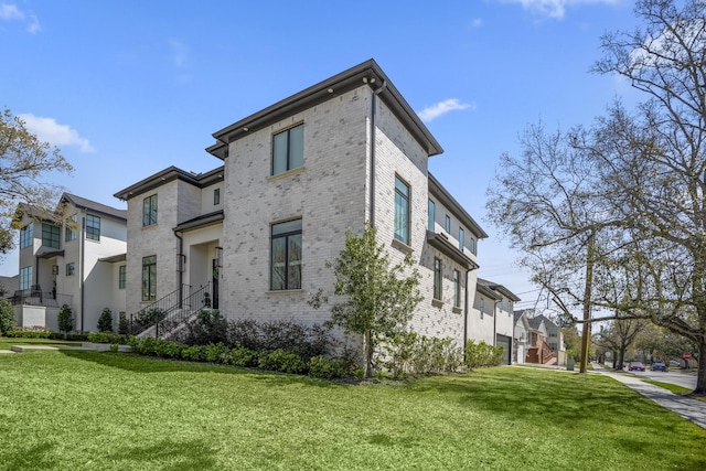 view of side of home featuring a yard and brick siding