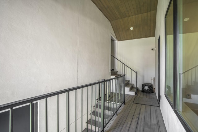 stairs with wooden ceiling and wood finished floors