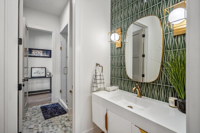 bathroom with a shower stall, tile walls, and vanity