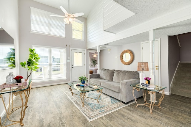 living area featuring a textured ceiling, a healthy amount of sunlight, wood finished floors, and ceiling fan