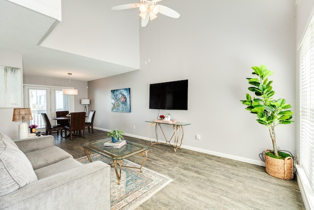 living room with a ceiling fan, wood finished floors, and baseboards