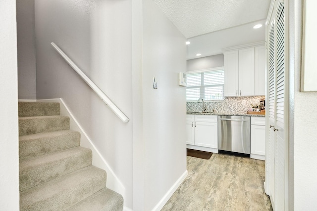 interior space with recessed lighting, a textured ceiling, baseboards, and wood finished floors