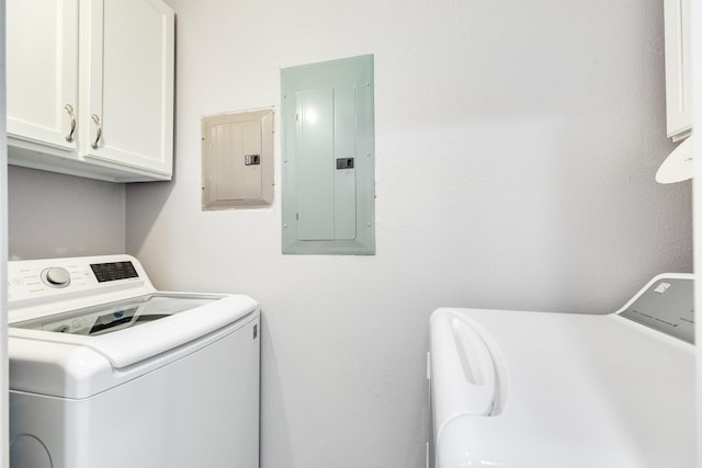 washroom with electric panel, cabinet space, and washing machine and dryer