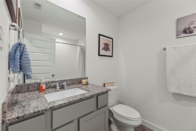 bathroom with vanity, a shower with shower curtain, baseboards, visible vents, and toilet