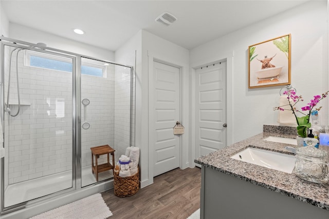 bathroom featuring visible vents, wood finished floors, recessed lighting, a shower stall, and vanity