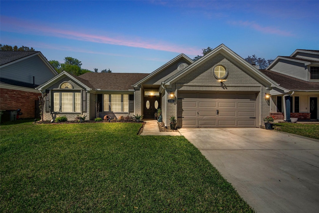 ranch-style home with brick siding, an attached garage, concrete driveway, and a front yard