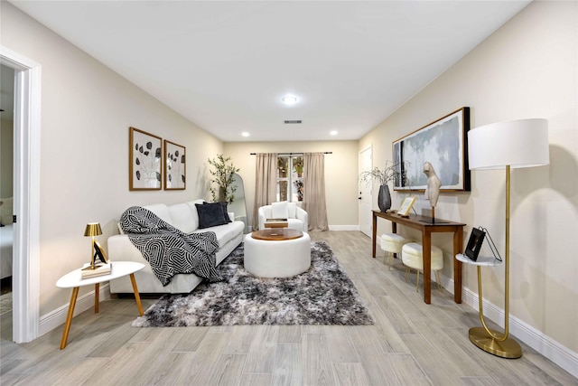 living room featuring recessed lighting, visible vents, baseboards, and light wood finished floors