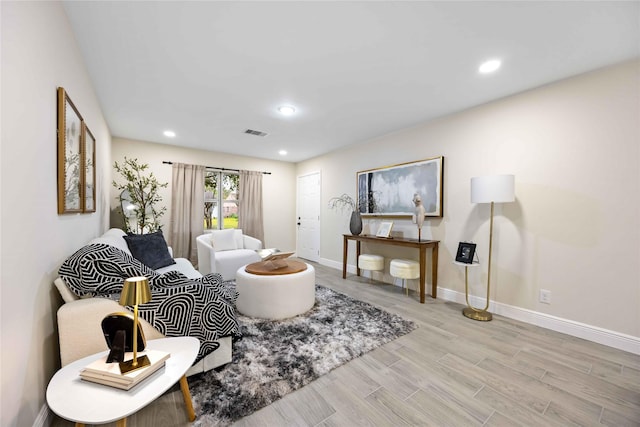 living area featuring light wood finished floors, visible vents, recessed lighting, and baseboards