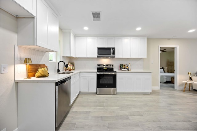 kitchen with visible vents, backsplash, light countertops, stainless steel appliances, and a sink