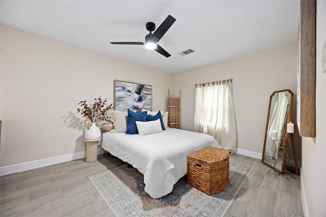 bedroom featuring light wood finished floors, visible vents, and baseboards