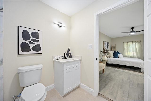 ensuite bathroom featuring baseboards, toilet, ensuite bath, and ceiling fan