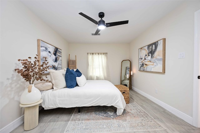 bedroom with visible vents, baseboards, ceiling fan, and light wood finished floors