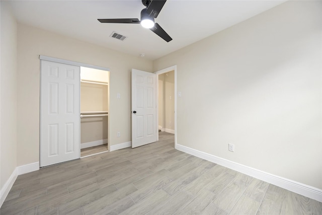 unfurnished bedroom with baseboards, visible vents, a closet, and light wood-type flooring